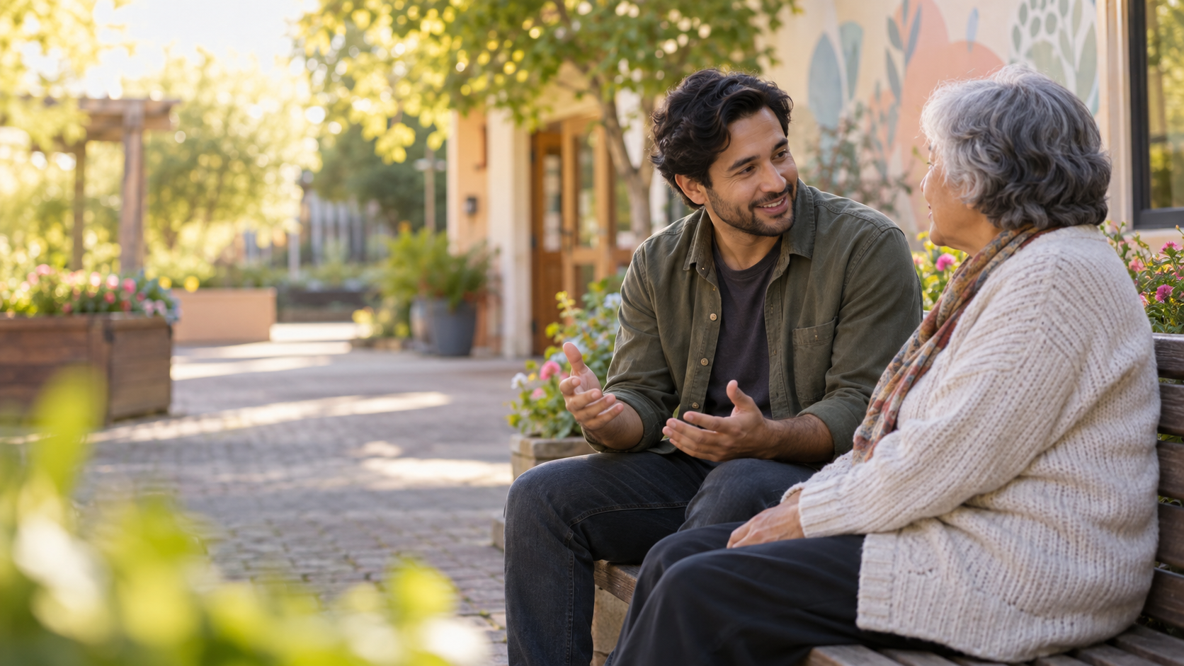 A community support worker listening to an older adult outside a welcoming community space